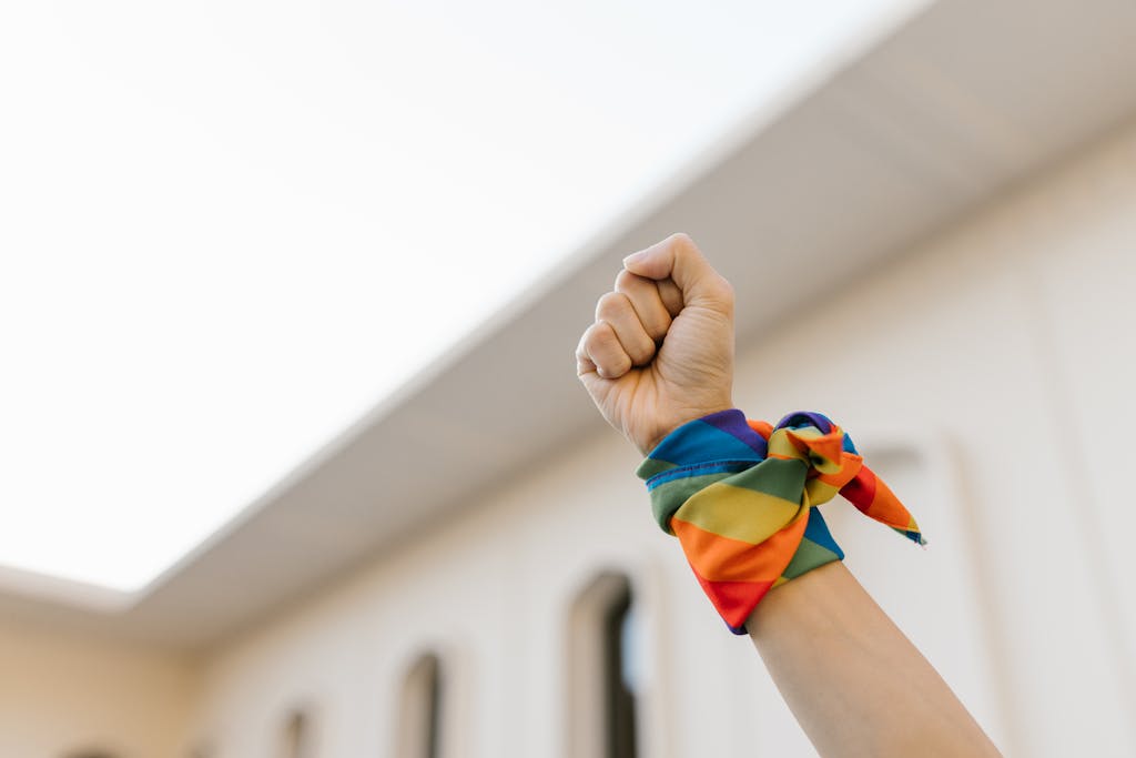 Unrecognizable Raised Fist and Wrist Wrapped in Rainbow Cloth 