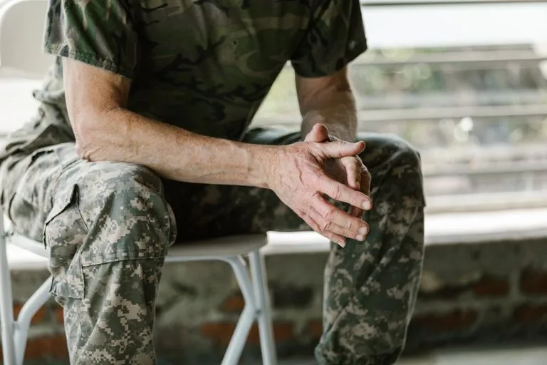 Close-up of a military veteran's hands in a therapy session, emphasizing mental health support. cannabis for veterans.